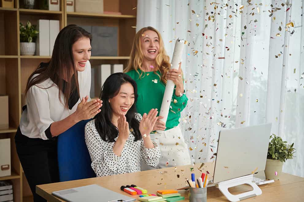 lancement de produit fait par evenement virtuel pour entreprise. 3 femmes dans une office en avant d'un laptop